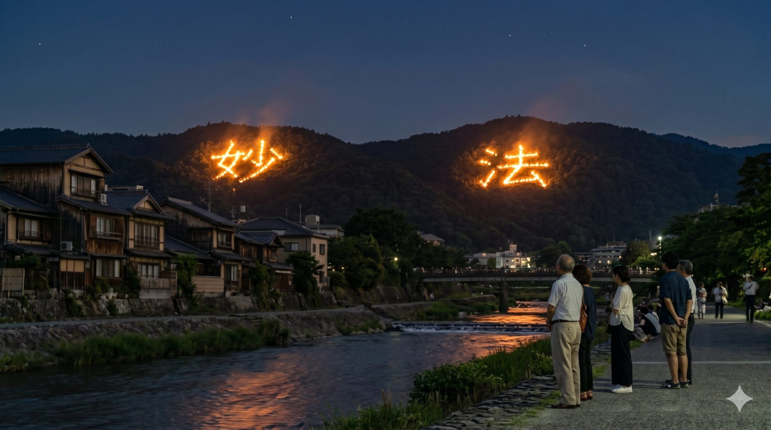 京都の高野川沿いの土手から眺める、夜空に並んで灯る松ケ崎の「妙」と「法」の送り火。