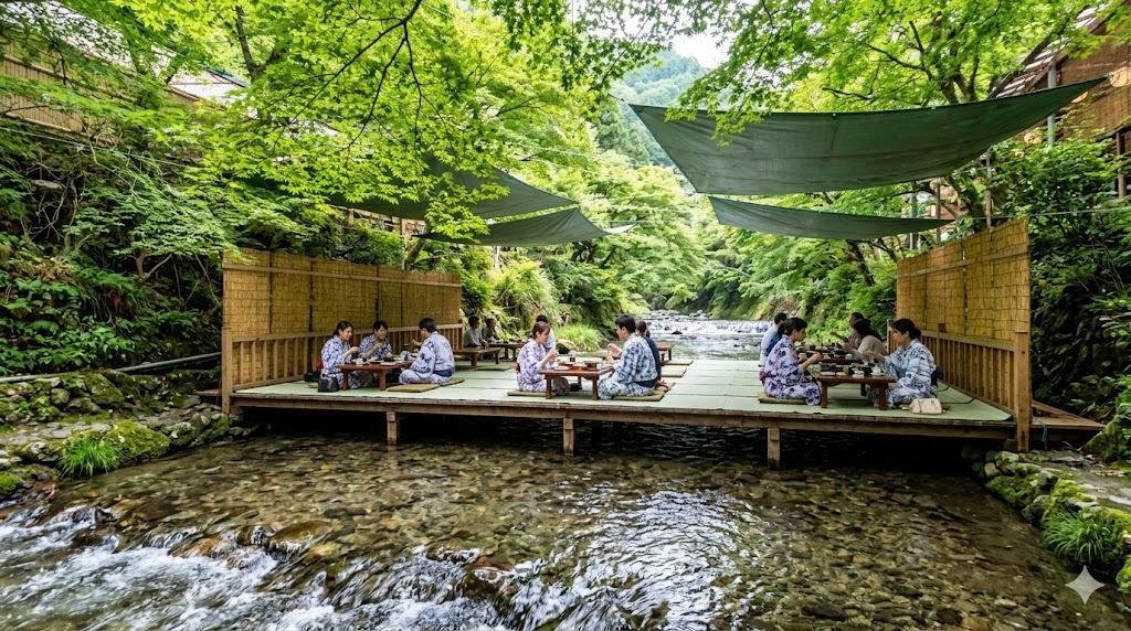 京都・貴船の夏の風物詩「川床」。清流の上に架けられた木座敷で、浴衣姿の日本人観光客たちが青もみじに囲まれながら涼やかに京料理ランチを楽しんでいる写真。川のせせらぎが聞こえるような臨場感がある。