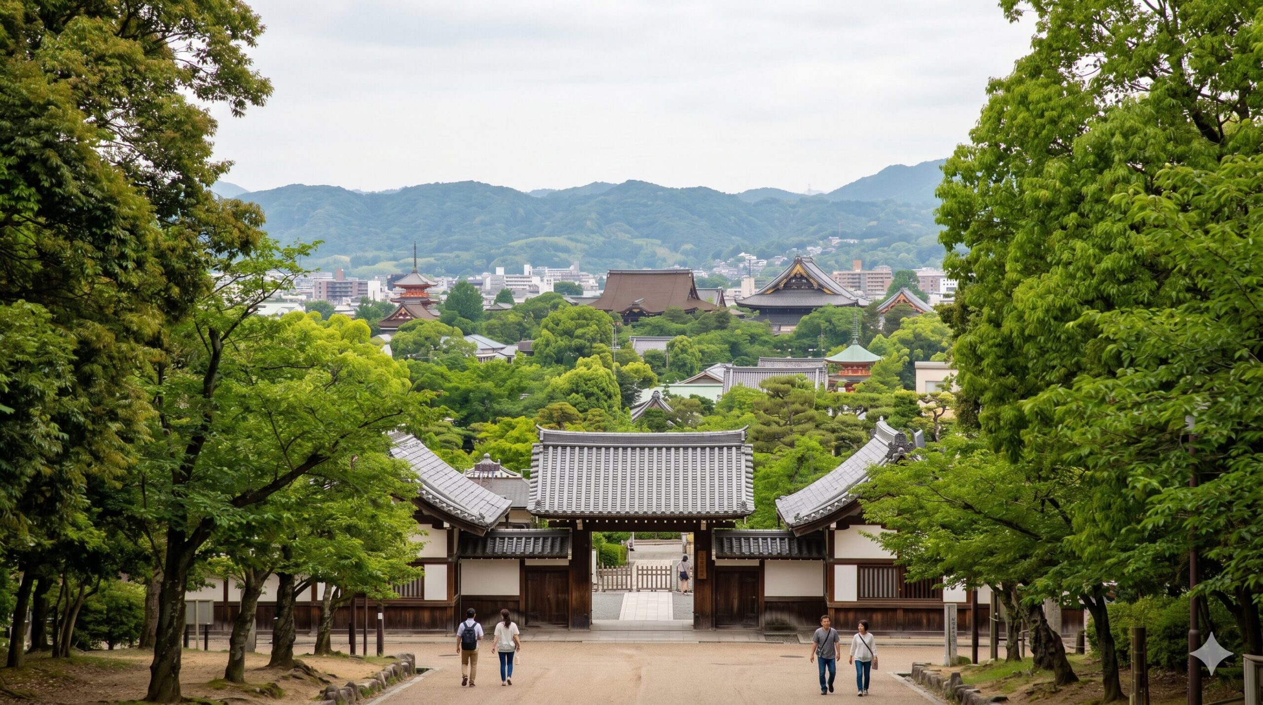 京都の東山エリアに位置する京都市動物園の入り口。伝統的な日本建築と、背景に見える平安神宮の大鳥居、山々の緑が調和した風景。アジア人（日本人）観光客が数人歩いている。テキストなし。