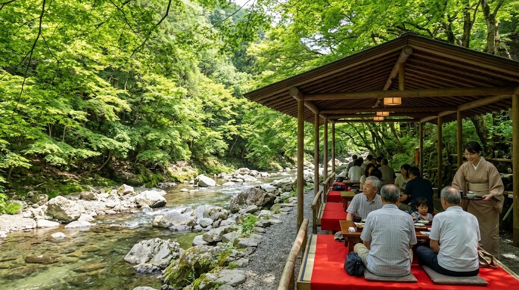 京都の自然豊かな高雄エリアを流れる清滝川沿いの屋根付き川床で、シニアや子連れの家族が赤毛氈の座敷に座り、和やかに京会席の和食ランチを囲む様子。