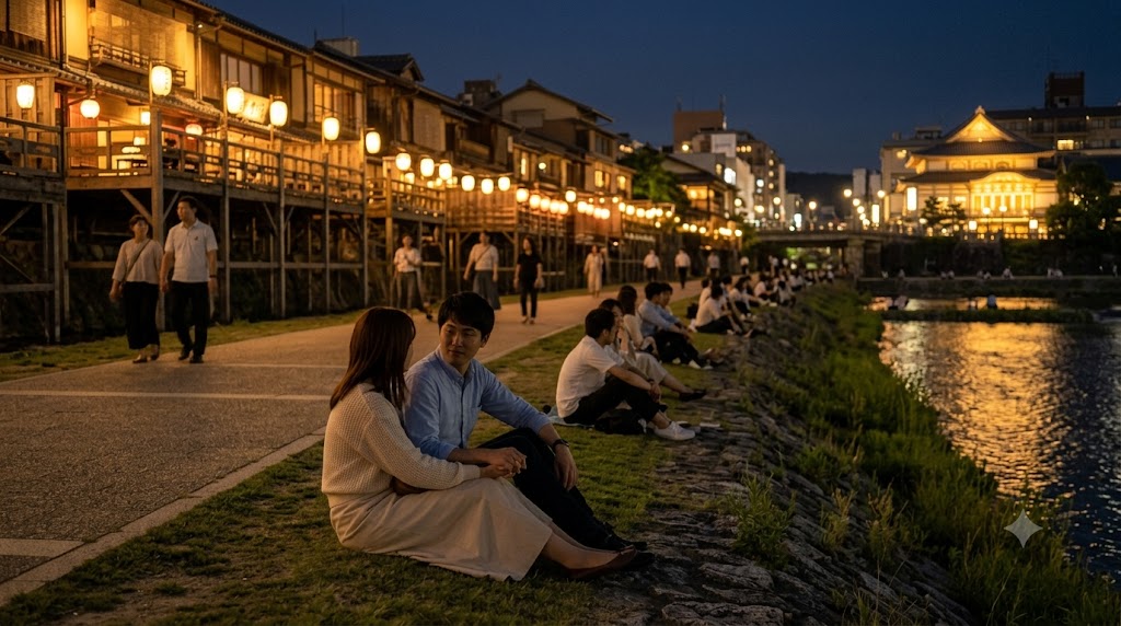 夜の鴨川。四条大橋付近。納涼床の提灯の明かりが川面に映り、等間隔に座るカップルたちのシルエットがロマンチックに浮かび上がっている。