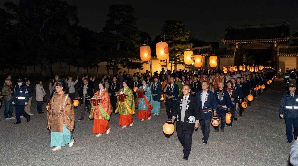 夜の京都御苑を進む禁裏御玄猪調貢ノ儀の行列。平装束の奉仕者と提灯を持つ参拝者が歩く様子