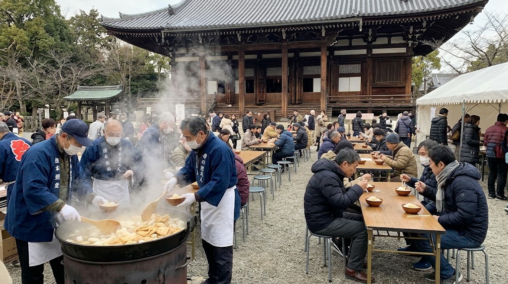 12月上旬、京都の千本釈迦堂（大報恩寺）で、冬服を着た大勢の参拝客が本堂前の長テーブルで温かい大根焚きを食べる賑やかな様子